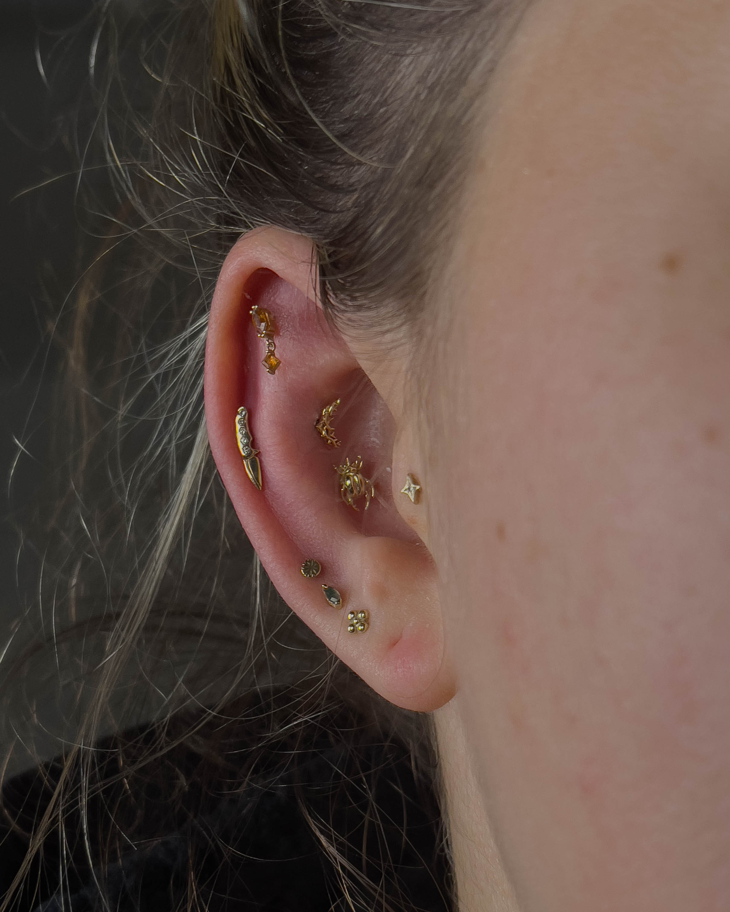 Finished ear curation with gold and titanium by Stab Daddy Bri